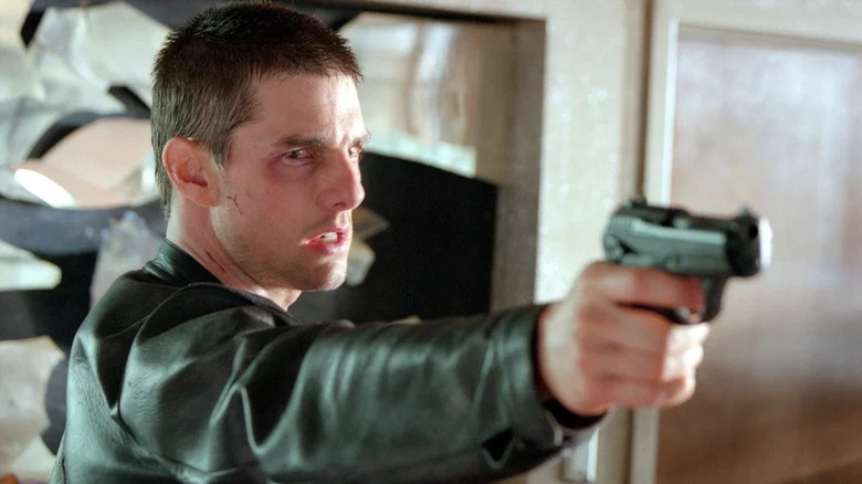 John Anderton holds gun