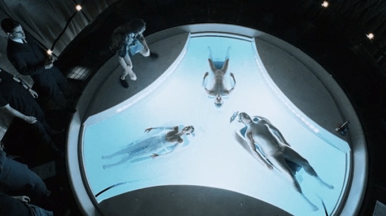 Men observe three precogs in a tank