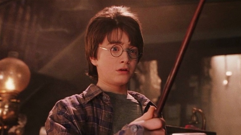 Harry Potter holds his wand in 