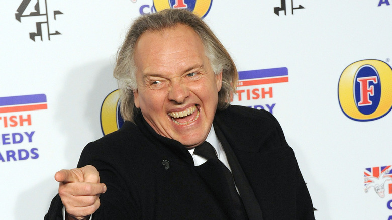 Rik Mayall laughing and pointing finger