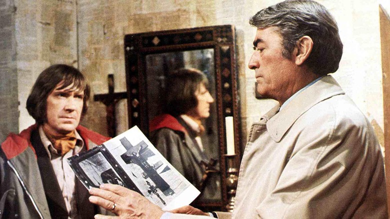 Gregory Peck holding book as David Warner watches in "The Omen" (1976)