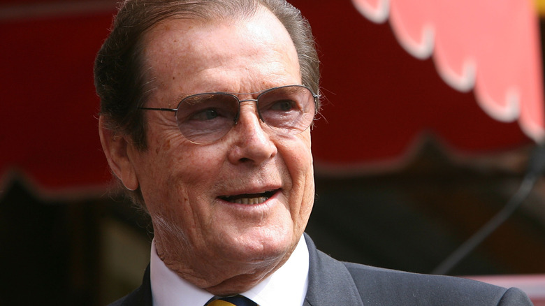 Roger Moore smiling for the press