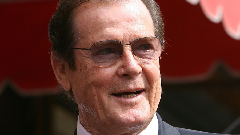 Roger Moore smiling for the press