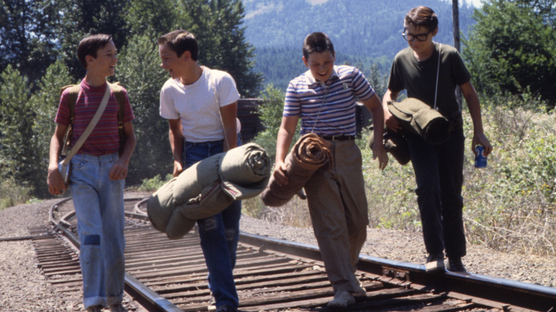 Gordie, Chris, Vern, and Teddy walking along train tracks in Stand by Me (1986)