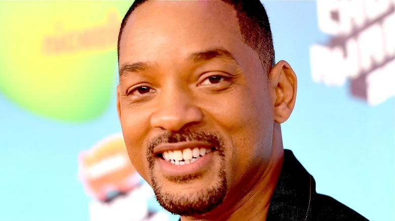 Will Smith smiles blue green background