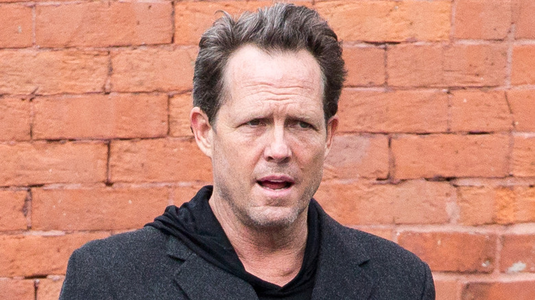 Dean Winters in front of a brick wall