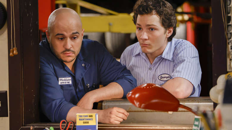 Georgie and Ruben in a window at McAllister Auto in "Georgie and Mandy's First Marriage" (2025)