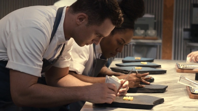Chefs prepare a course in The Menu