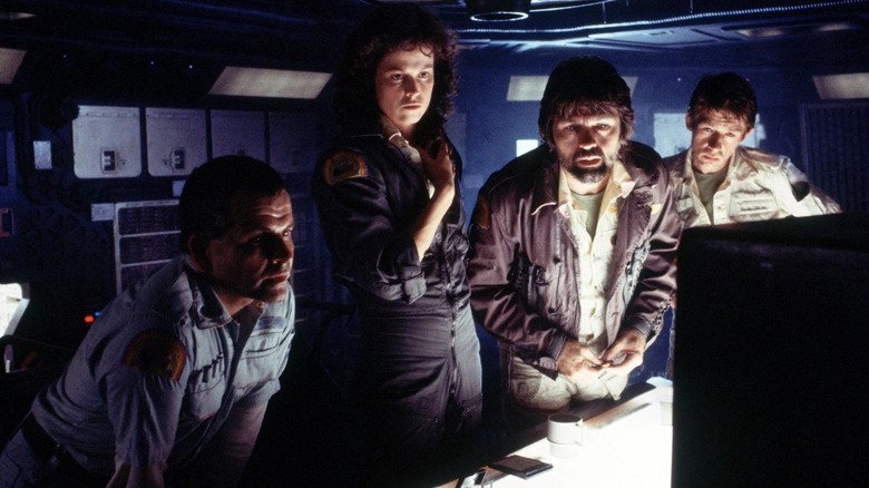 Ripley, Dallas, and Kane examine a monitor with Ash in Alien (1979)