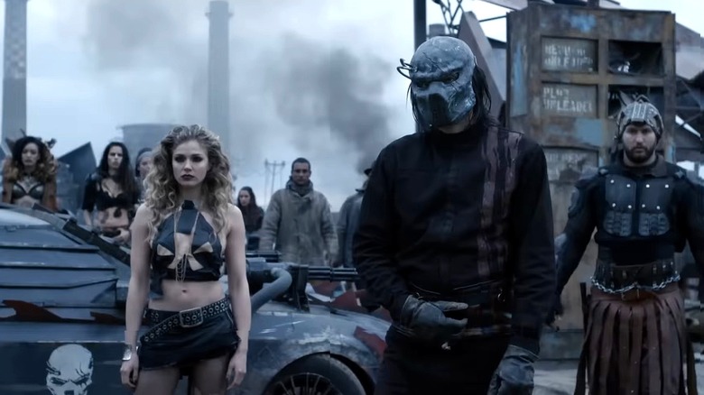 Racers standing around a car in Death Race: Beyond Anarchy (2018)
