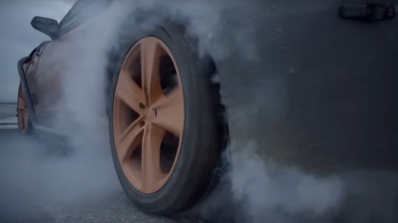 Tire spinning up smoke on ground