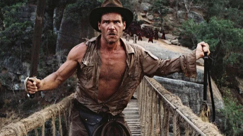 Indy holds the missing idol over the bridge in Indiana Jones and the Temple of Doom (1984)