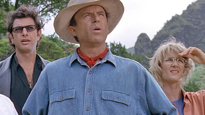 Ian Malcolm (Jeff Goldblum), Alan Grant (Sam Neill), and Ellie Sattler (Laura Dern) look up at new dinosaurs in Jurassic Park (1993)