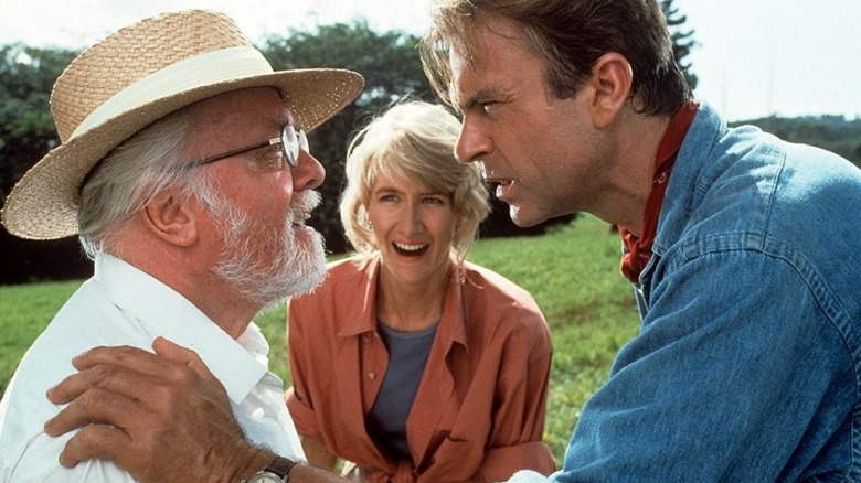 Alan Grant (Sam Neill) and Ellie Sattler (Laura Dern) speak with John Hammond (Richard Attenborough) in Jurassic Park (1993)