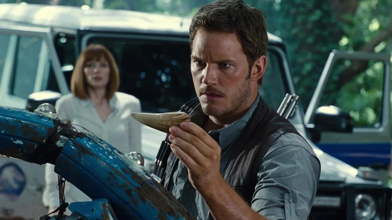 Owen Grady (Chris Pratt) finds a claw as Claire Dearing (Bryce Dallas Howard) waits in the background in Jurassic World (2015)