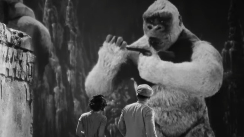 Carl and Hilda look at Little Kong holding gun in "Son of Kong" (1933)
