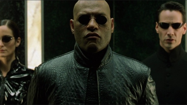 Morpheus stands with Neo and Trinity in "The Matrix" (1999)