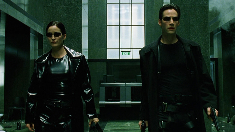 Neo and Trinity walk down a hallway in "The Matrix" (1999)