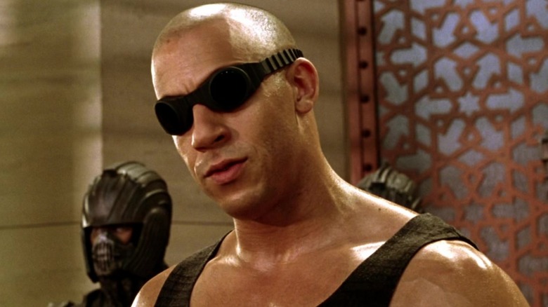 Riddick wearing goggles and cocking head to the side in Chronicles of Riddick (2004)