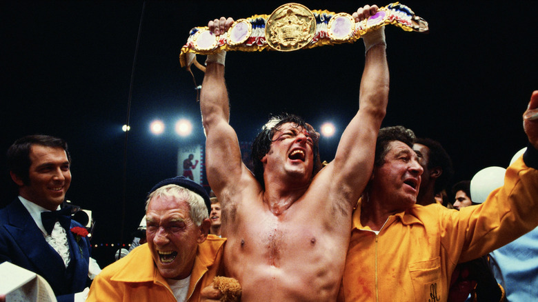 Rocky Balboa holds up his award beside his team in Rocky II (1979)