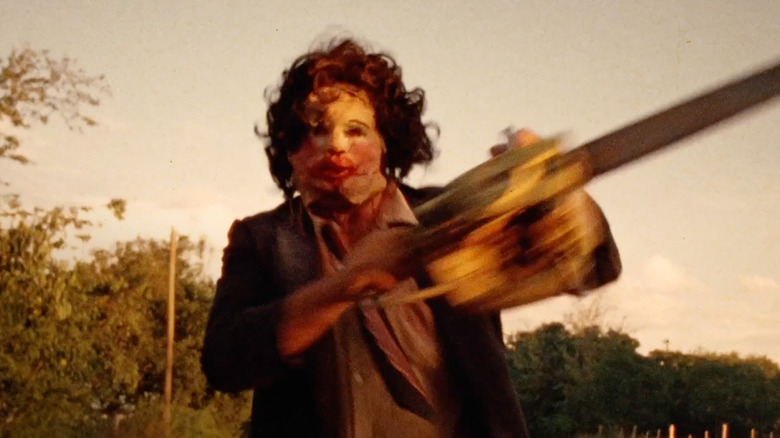 Leatherface wielding a chainsaw outside in "The Texas Chainsaw Massacre."