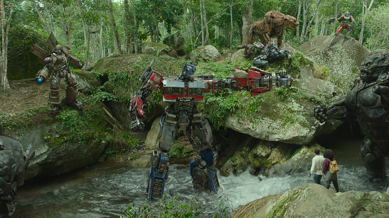 Rhinox, Wheeljack, Optimus Prime, Mirage, Cheetor, Arcee, Optimus Primal standing around Noah and Elena
