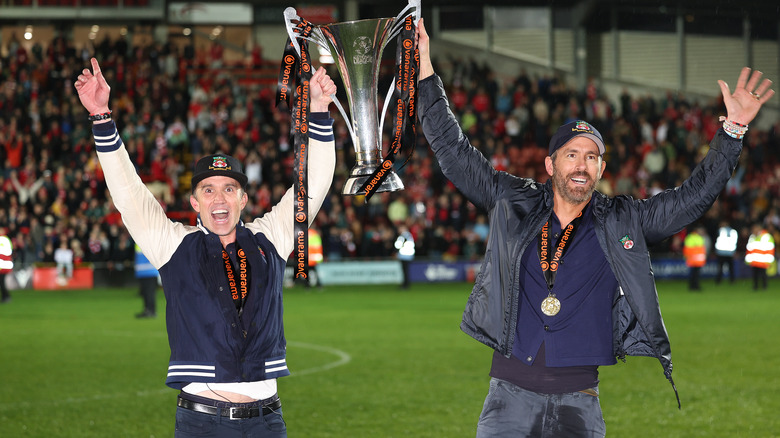 Rob McElhenney and Ryan Reynolds holding trophy