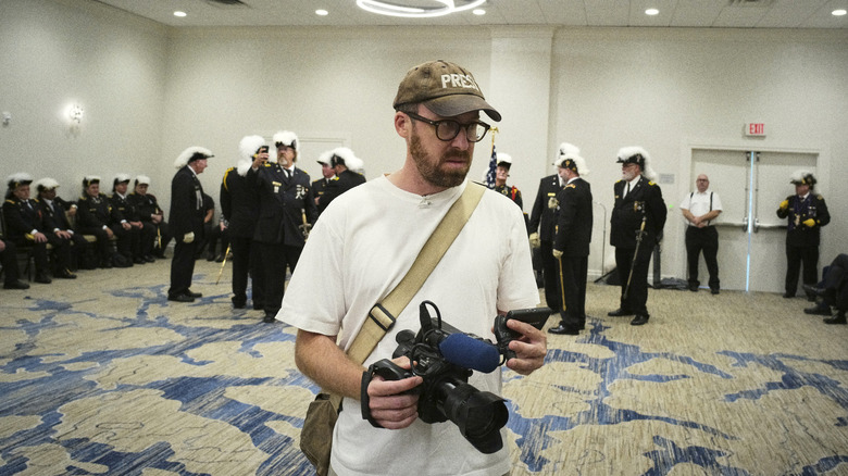 John Wilson holding camera