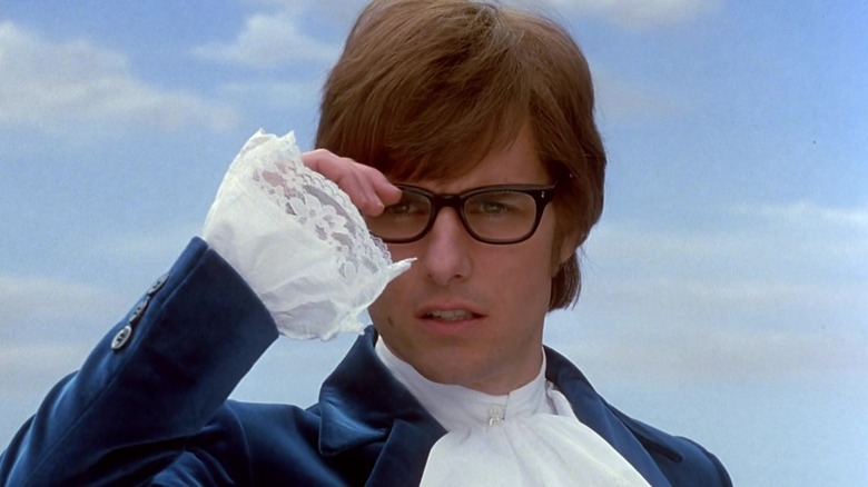 Tom Cruise as Austin Powers holding glasses