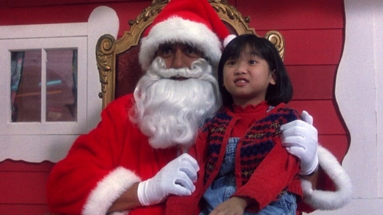 Thorn dressed as Santa, with a little girl on his knee in Santa with Muscles