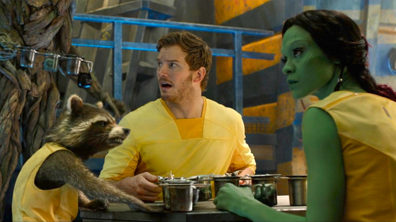Gamora, Rocket, and Peter Quill sitting at a table next to Groot