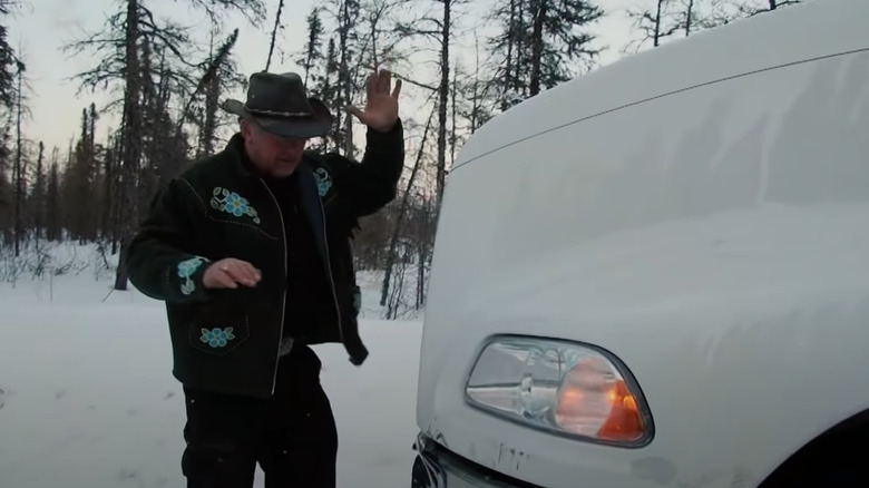 Alex checks damage on the front of his truck in Ice Road Truckers