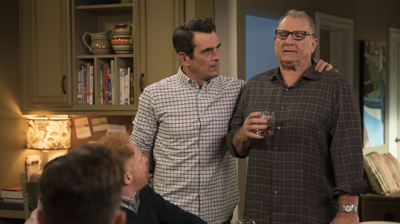 Ty Burrell as Phil Dunphy stands next to Ed O'Neill as Jay Pritchett on Modern Family.