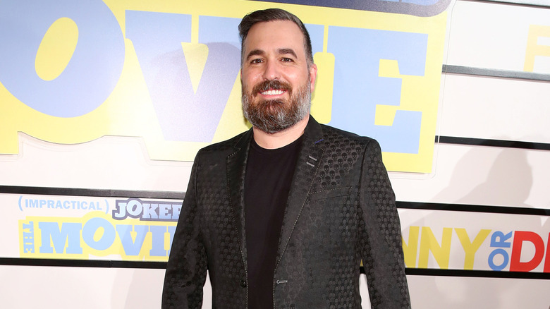 Brian "Q" Quinn smiling on an "Impractical Jokers" red carpet