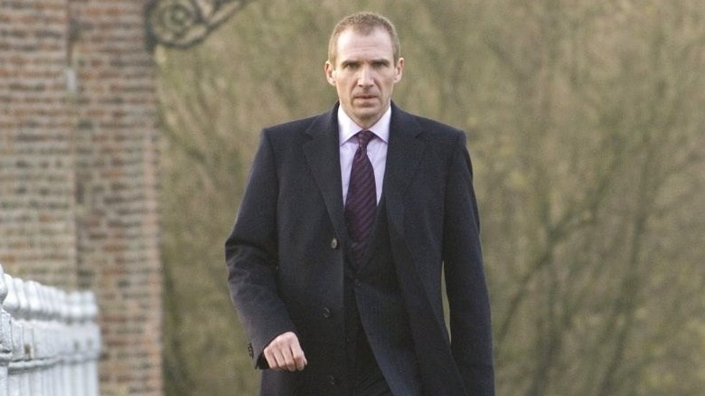 Ralph Fiennes walking across a bridge