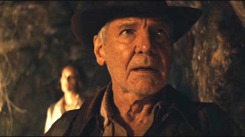 Indiana Jones looks intently in cave