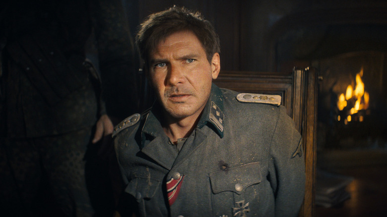 Indiana Jones tied to a chair wearing a military uniform