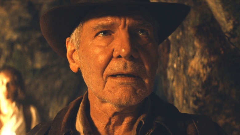 Indiana Jones stands in a cave