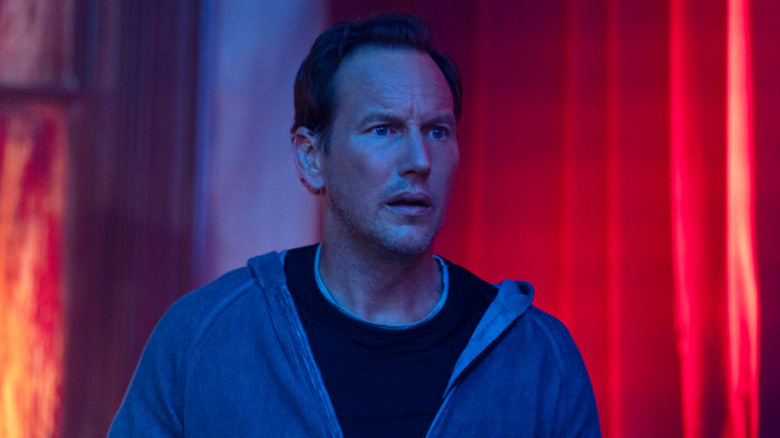 Patrick Wilson surrounded by red curtains