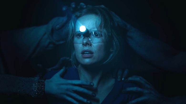 Gemma wearing a flashlight while hands grab her in "Insidious: Out of the Further" (2026)