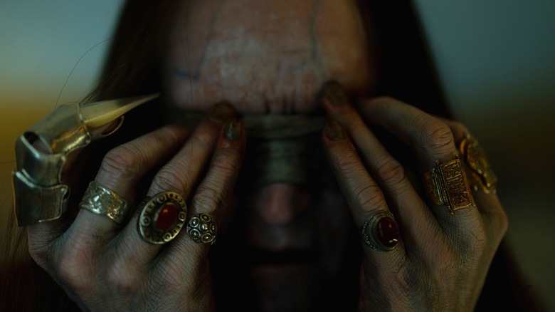 Cyrus Lam holding bandage to his eyes in "Insidious: Out of the Further" (2026)