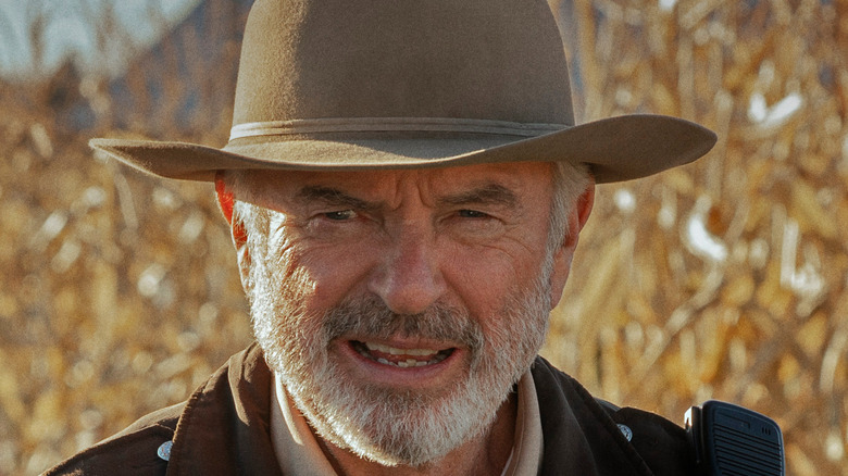 Sam Neill squinting and wearing hat