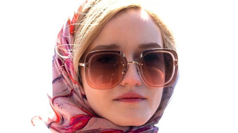 Julia Garner as Anna Delvey wearing sunglasses