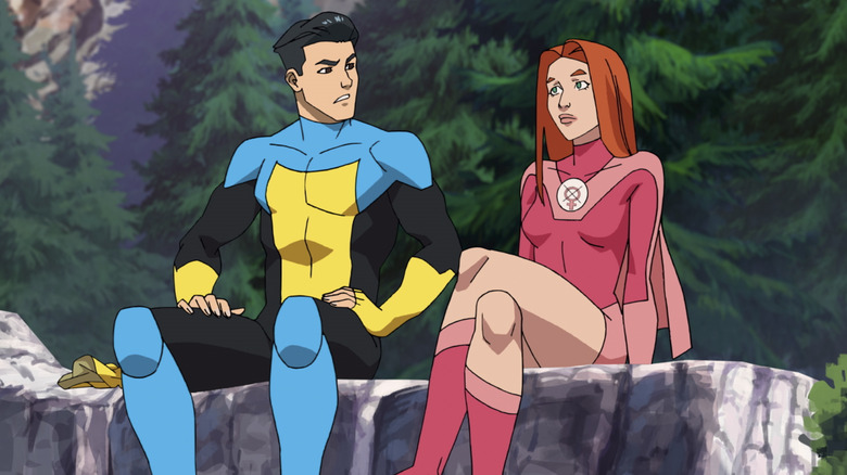 Invincible and Atom Eve sitting on a rock