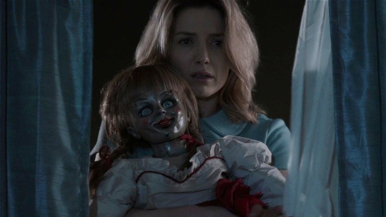 Mia holding Annabelle while looking sad