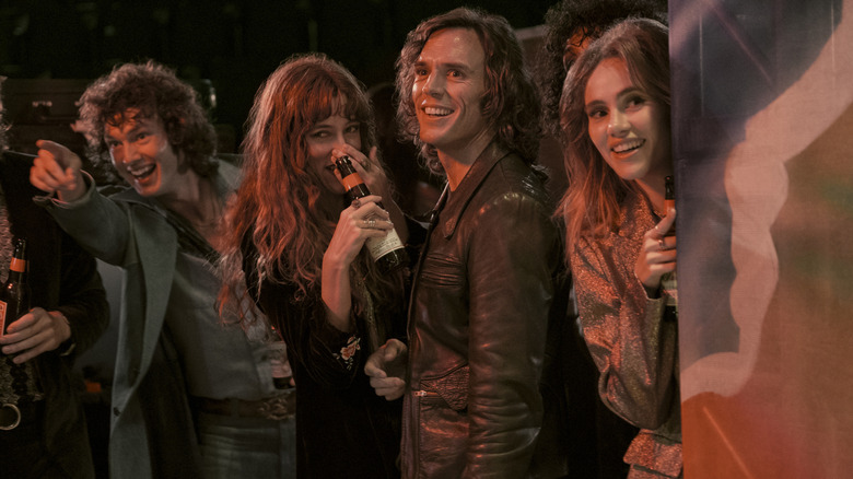 Band peering around corner laughing in Daisy Jones & the Six