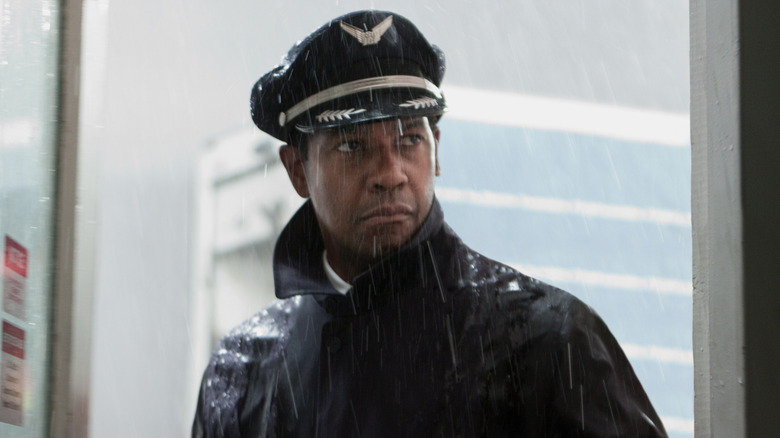 Captain Whitaker standing in doorway while it rains outside