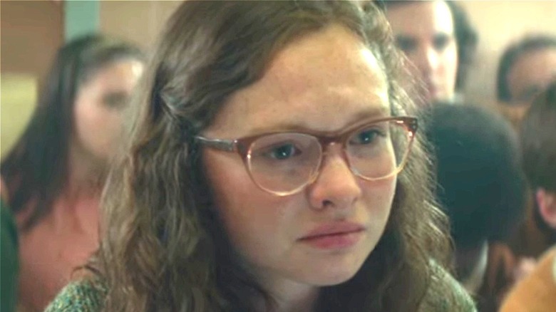 young girl with glasses looks very scared