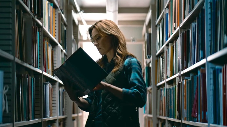 Mia Brennan amidst library stacks in Shelby Oaks