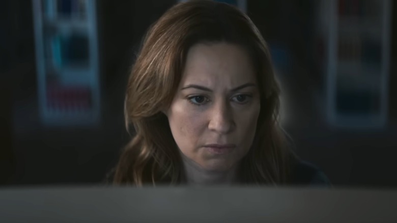 Mia Brennan studying a computer in Shelby Oaks